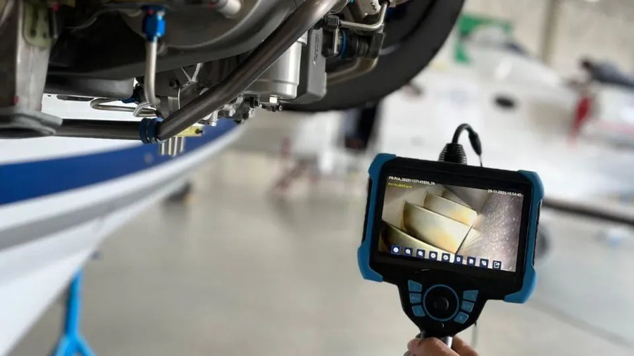 Handheld industrial videoscope displaying an internal view during component inspection